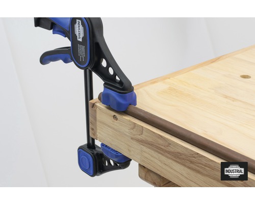 Stabzwinge fixiert ein Werkstück auf einer Werkbank.