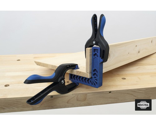 Deux serre-joints fixent des pièces de bois sur un établi