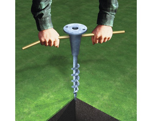 Une personne tourne une ancre de sol dans le sol à l''aide d''une tige.