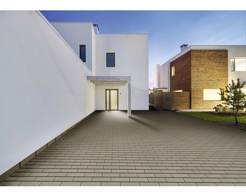 Aussenbereich mit Pflastersteinen vor modernen Wohnhäusern.