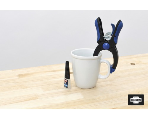 Scène avec serre-joint à ressort, colle et tasse sur un établi