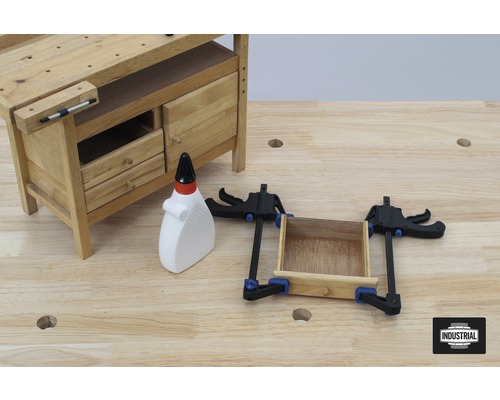 Werkbank mit Schubladen, Holzleim und Zwingen auf einer Holzoberfläche