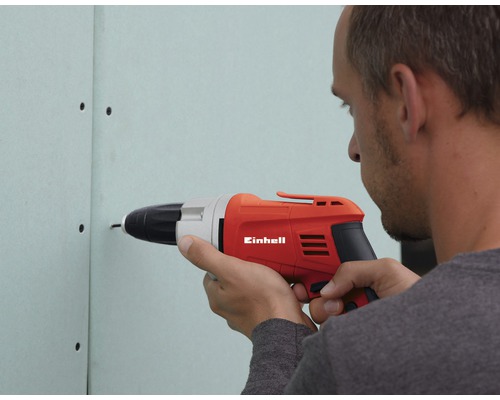 Un homme visse une vis dans une plaque de plâtre à l''aide d''une visseuse sans fil Einhell
