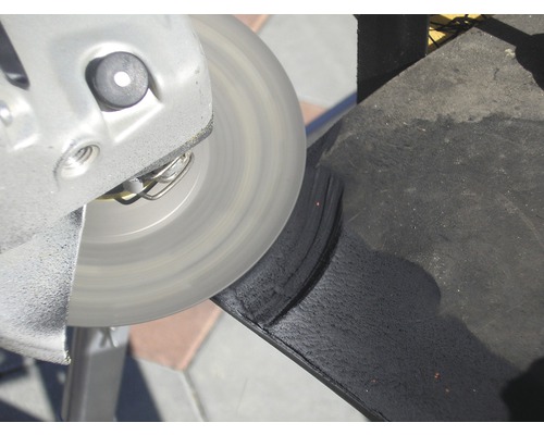 Eine Schleifscheibe bearbeitet ein schwarzes Material.