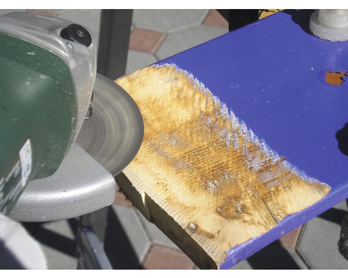 Eine Schleifmaschine bearbeitet ein Holzbrett.