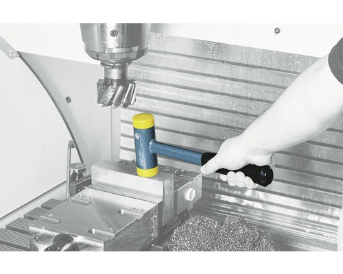 Hand hält Hammer auf Werkbank