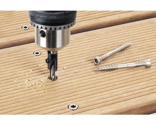 Foret à fraiser en cours d''utilisation sur une terrasse en bois avec deux vis de terrasse