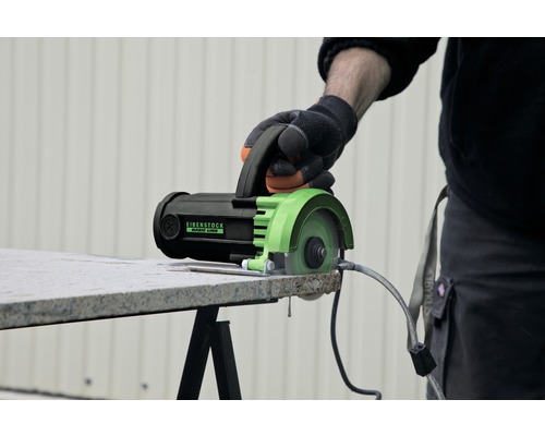 Une main actionne une carreleuse Eibenstock pour couper un carreau.