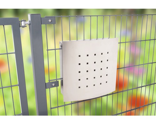 Briefkasten mit quadratischen Löchern an einem Gitterzaun