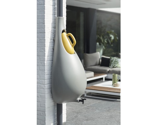 Stockage d''eau gris avec arrosoir jaune à l''extérieur.