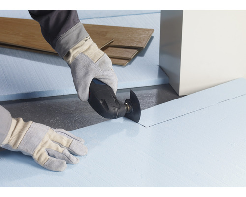 Un artisan coupe des plaques isolantes avec un outil multifonction