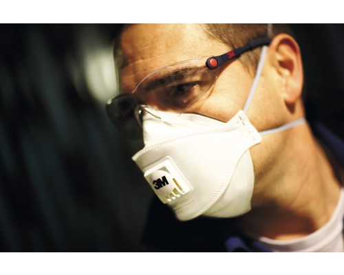 Un homme porte un masque respiratoire et des lunettes de protection pour la sécurité au travail.