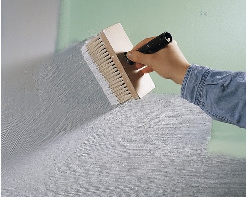 Une personne applique de la peinture sur un mur à l''aide d''une brosse.