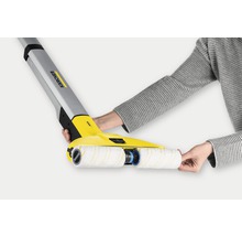 Nettoyeur de sols durs Kärcher avec rouleaux rotatifs en cours d''utilisation.