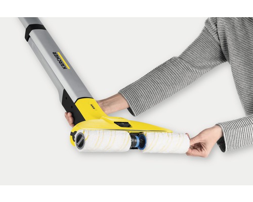 Nettoyeur de sols durs Kärcher avec rouleaux rotatifs en cours d''utilisation.