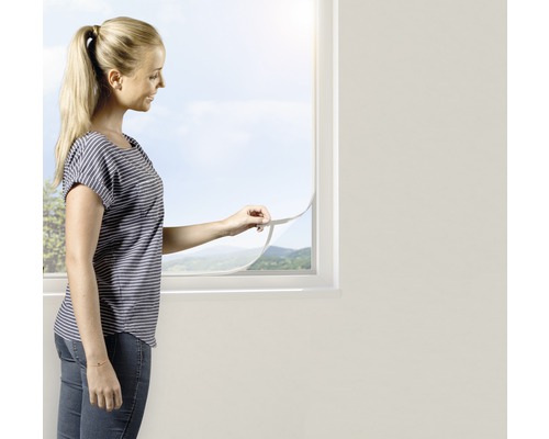 Moustiquaire Open-Up protection contre les insectes sans perçage blanc 130x150 cm Une femme installe une moustiquaire sur une fenêtre.