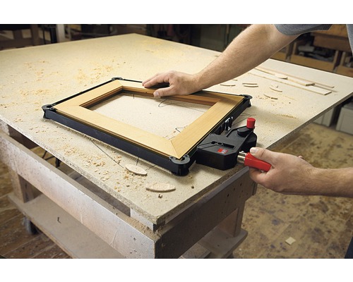 Holzrahmen wird mit einer Rahmenzwinge auf einer Werkbank fixiert.