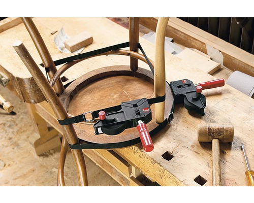 Ein Holzstuhl wird mit einem Umreifungsspanner auf einer Werkbank repariert