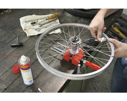 Fahrradreparatur mit Werkzeug, Felge und Speichen