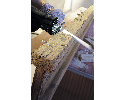 Eine Person sägt ein Holzbrett mit einer Säbelsäge.