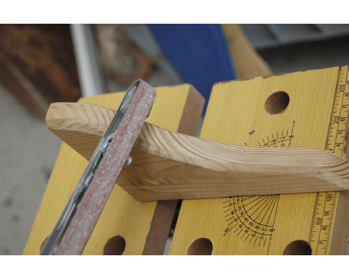 Holzbearbeitung mit einem Bandschleifer an einer Werkbank