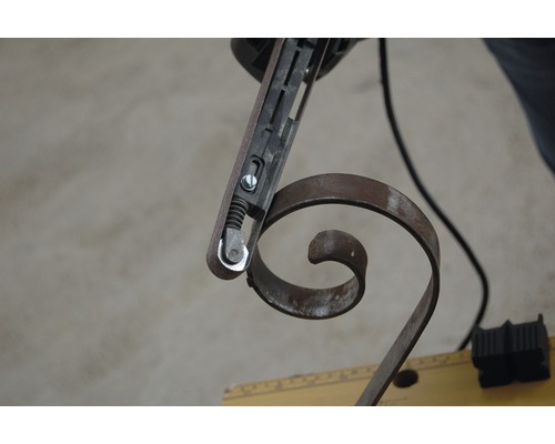 Bandschleifer beim Bearbeiten eines Metallornaments