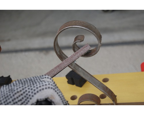 Verarbeitung von gebogenem Metallelement mit einer Feile.