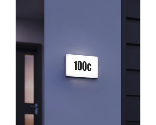 Plaque de numéro de maison éclairée avec le numéro 100c sur un mur
