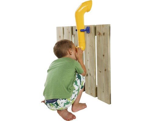 Un garçon utilise un téléphone jaune sur une clôture en bois pour une maison de jeux