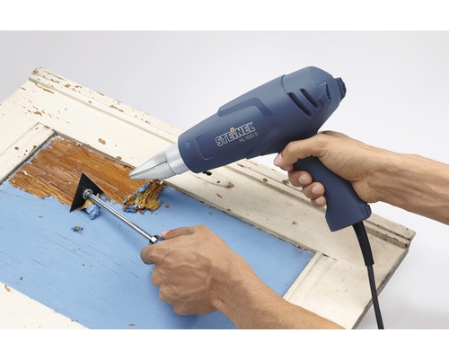 Abbeizen einer Tür mit einem Heißluftfön und einem Spachtel