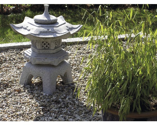 Dekorative Gartenlaterne aus Stein neben Bambus