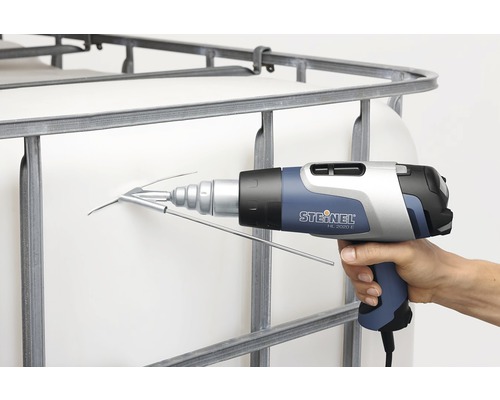 Main tenant un pistolet à air chaud Steinel HL 2020 E avec buse de soudure pour soudure plastique