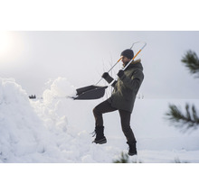 Eine Person schaufelt mit einer Schneeschaufel Schnee.