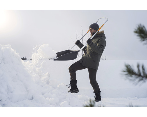 Une personne pelle de la neige avec une pelle à neige.