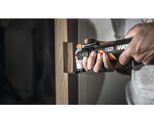 Ein Mann benutzt einen Multifunktionsschleifer von Worx für Holzarbeiten.