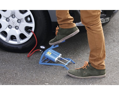 Fussluftpumpe beim Aufpumpen eines Autoreifens