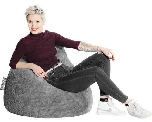 Frau sitzt in einem grauen Sitzsack.