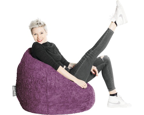 Femme assise confortablement sur un pouf violet.