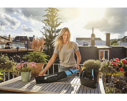 Une femme déballe des outils de jardinage d''un sac sur une table en bois.