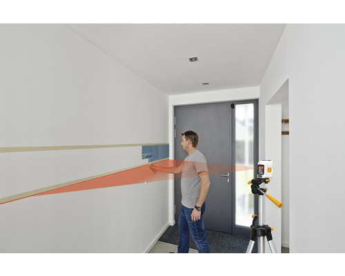 Mann verwendet einen Linienlaser zum Malen einer Wand