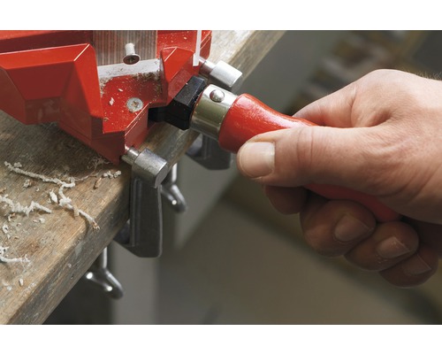 Une main manipule une équerre d''angle sur une pièce