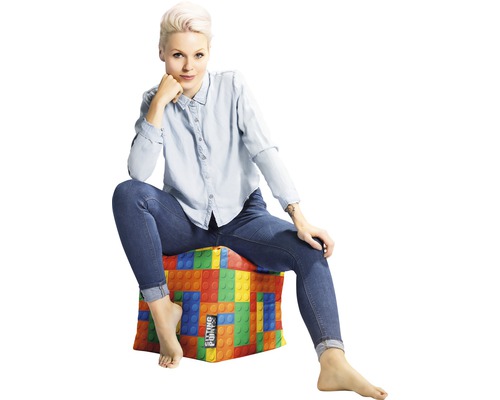 Frau sitzt auf Sitzwürfel mit Bauklotzdesign