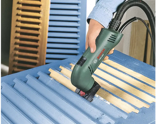 Une personne utilise un grattoir électrique Bosch pour poncer un volet.