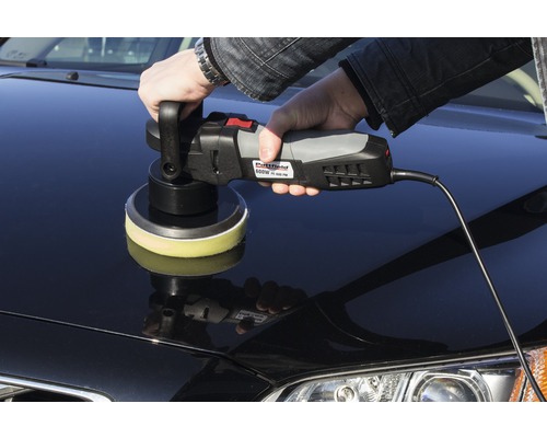 Eine Person poliert ein Auto mit einer Poliermaschine.
