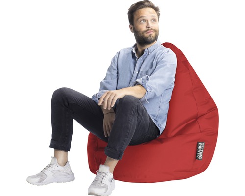 Homme assis sur un pouf rouge
