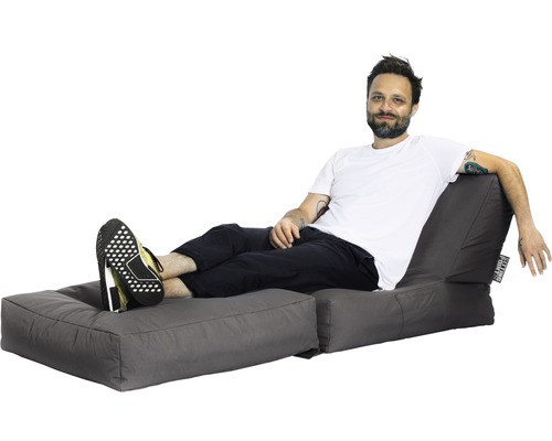 Mann entspannt sich auf einem grauen Sitzsack mit Fussteil