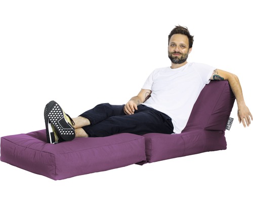 Mann entspannt sich auf einer violetten Sitzinsel mit Fußteil.