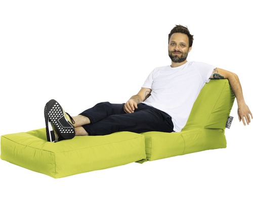 Mann entspannt sich auf einem hellen Sitzsack mit Fußhocker