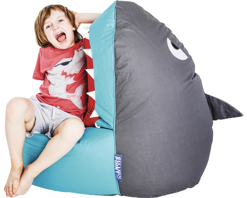 Garçon assis sur un pouf en forme de requin