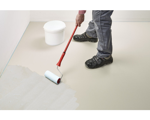 Une personne peint un sol avec un rouleau à peinture. Un seau de peinture est visible à l''arrière-plan.